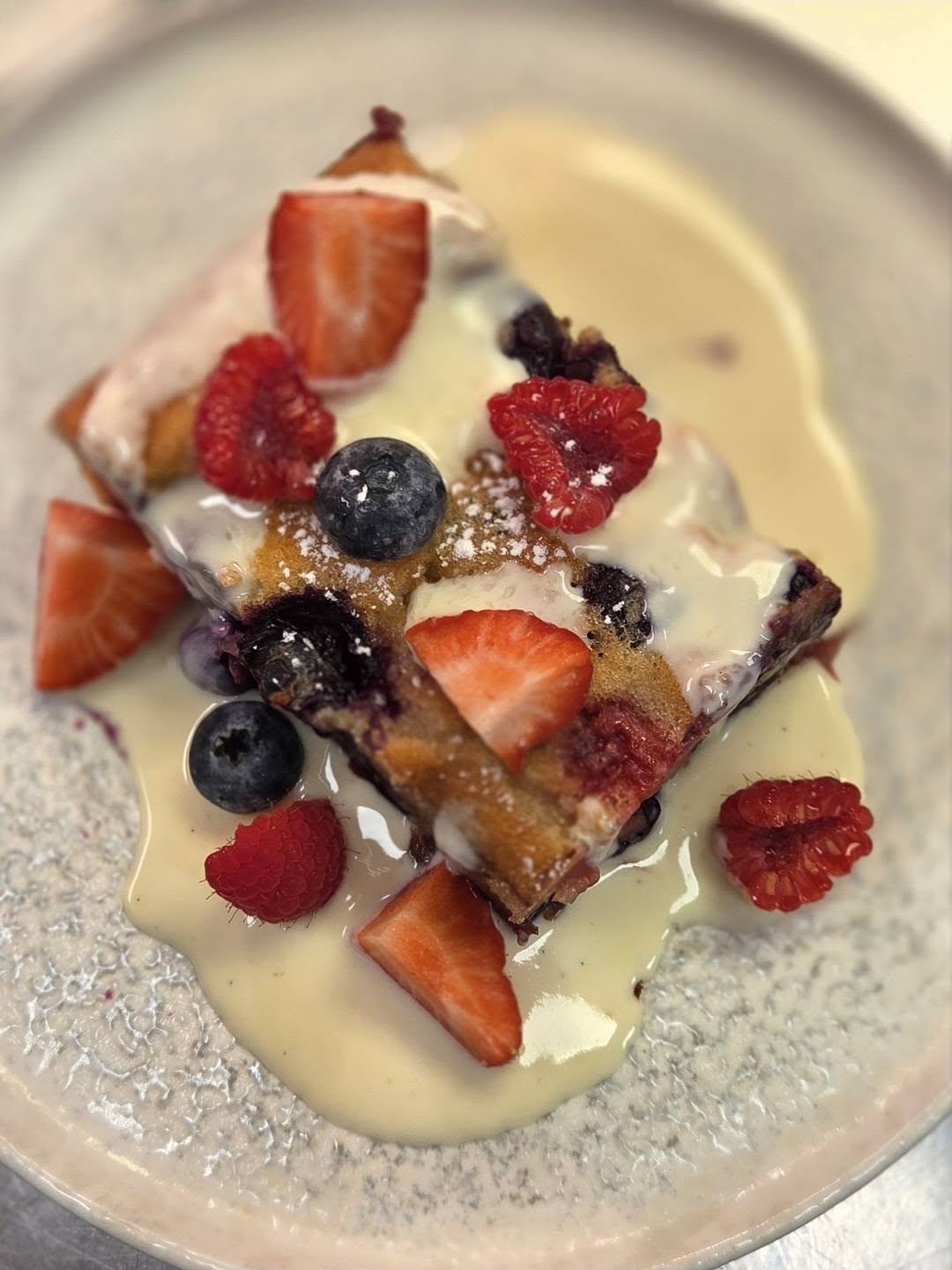 Berry pudding with vanilla custard and fresh fruit